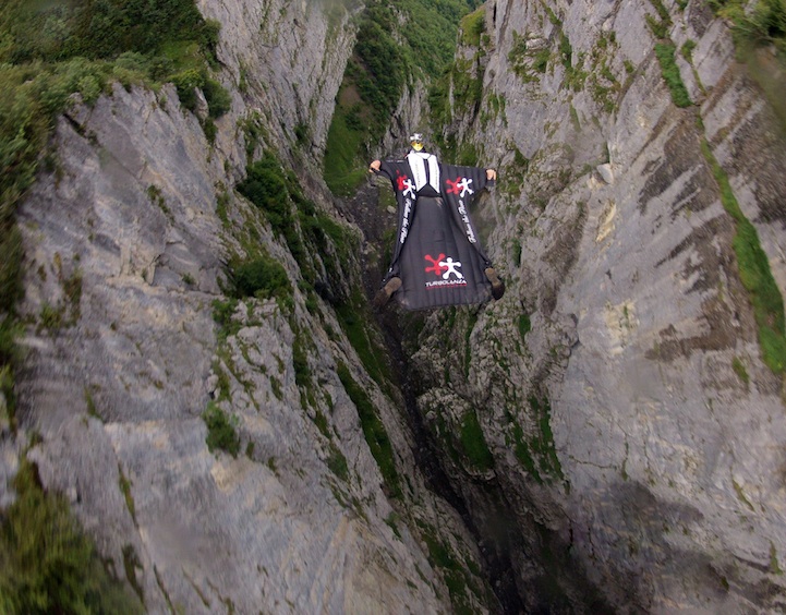 Roberta Mancino beim Flug durch einen Felsspalt. Aufgenommen in der Schweiz.